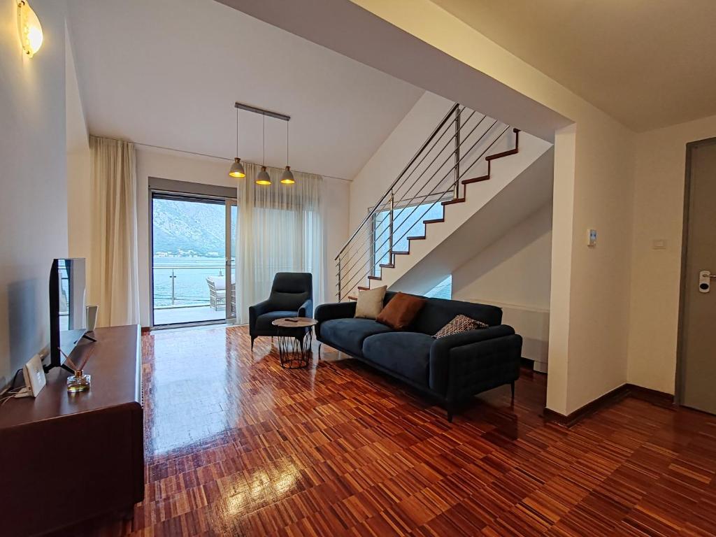 a living room with a couch and a staircase at Квартира с прекрасным видом на море in Donji Stoliv