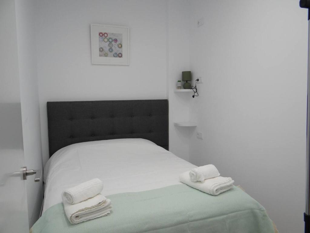 een slaapkamer met een bed met twee handdoeken erop bij Villa Cariño - Apartamento en Malpica de Bergantiños in Malpica