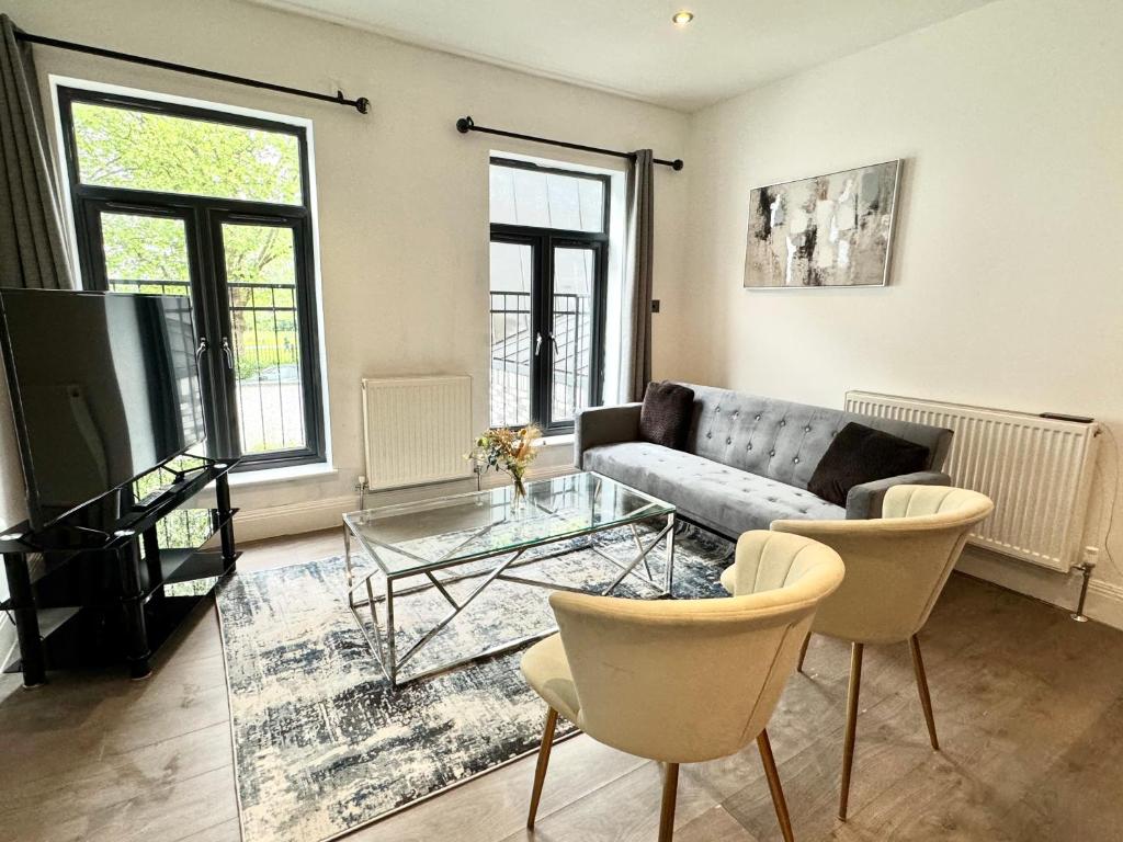 a living room with a couch and a glass table at Luxurious Hidden Gem in Wandsworth in London