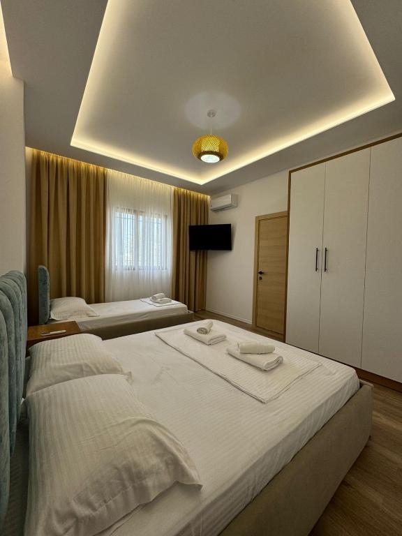 a bedroom with two beds with towels on them at VILA GOLDEN SAND in Ksamil