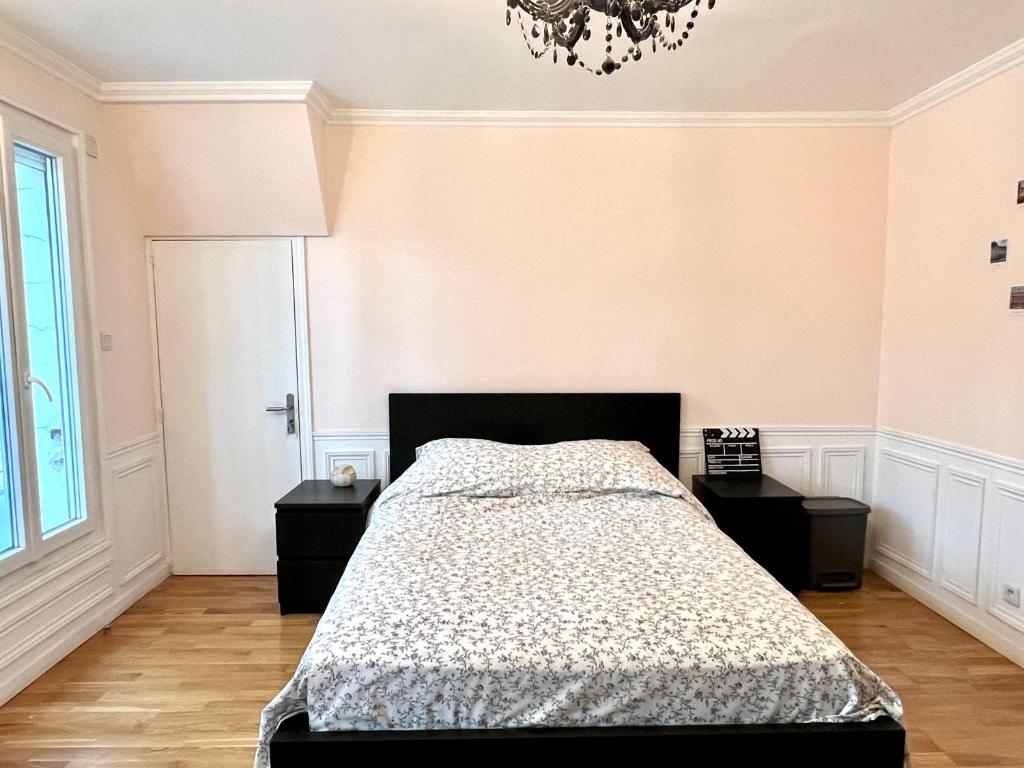 a bedroom with a bed and two night stands at Appartement à côté des épreuves olympiques in Pierrefitte-sur-Seine