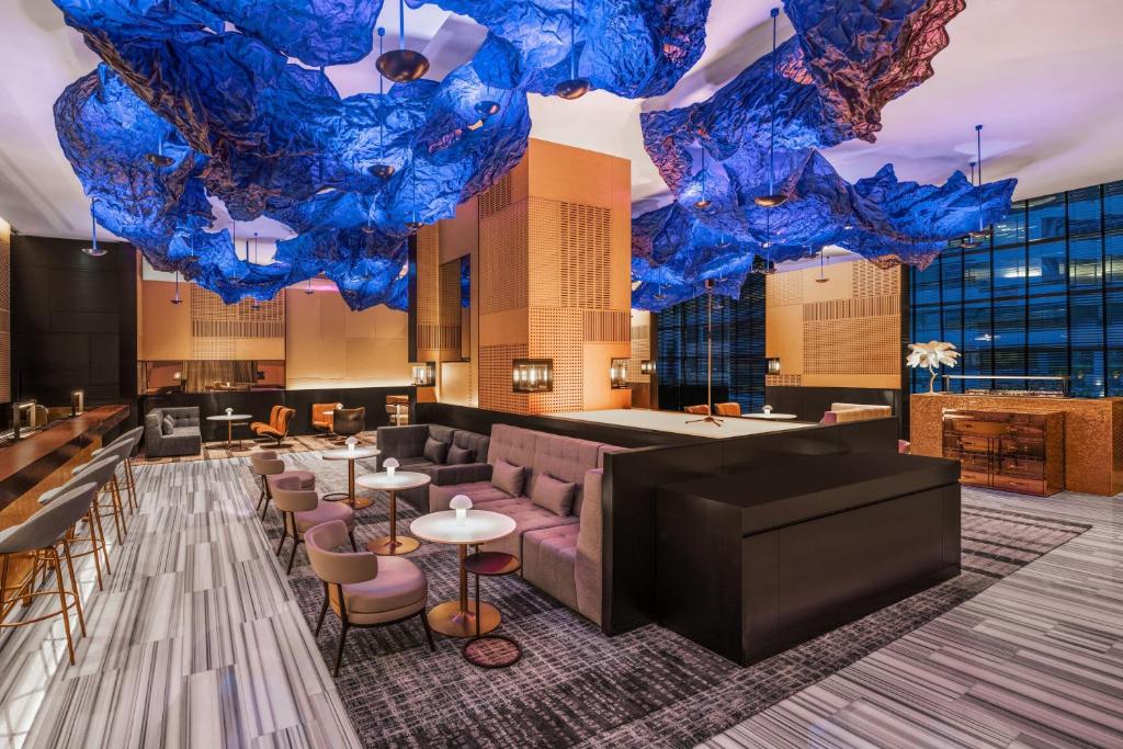 A hotel lounge and bar beneath multiple blue ceiling sculptures.