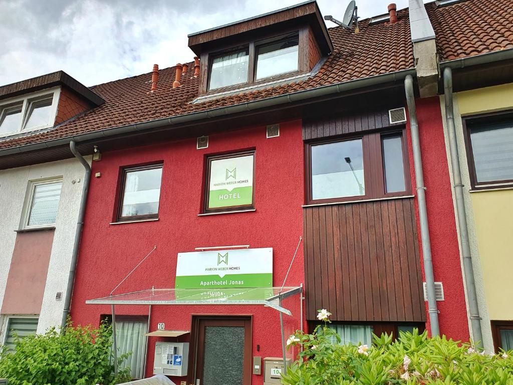 un bâtiment rouge avec un panneau devant lui dans l'établissement Aparthotel Jonas, à Brême