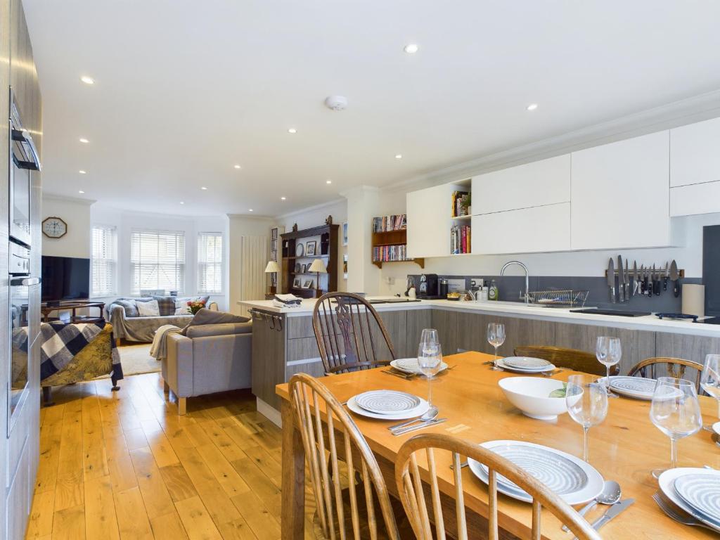 een keuken en eetkamer met een tafel en stoelen bij Queens Mews a contemporary beach side holiday home for 6 in Ryde