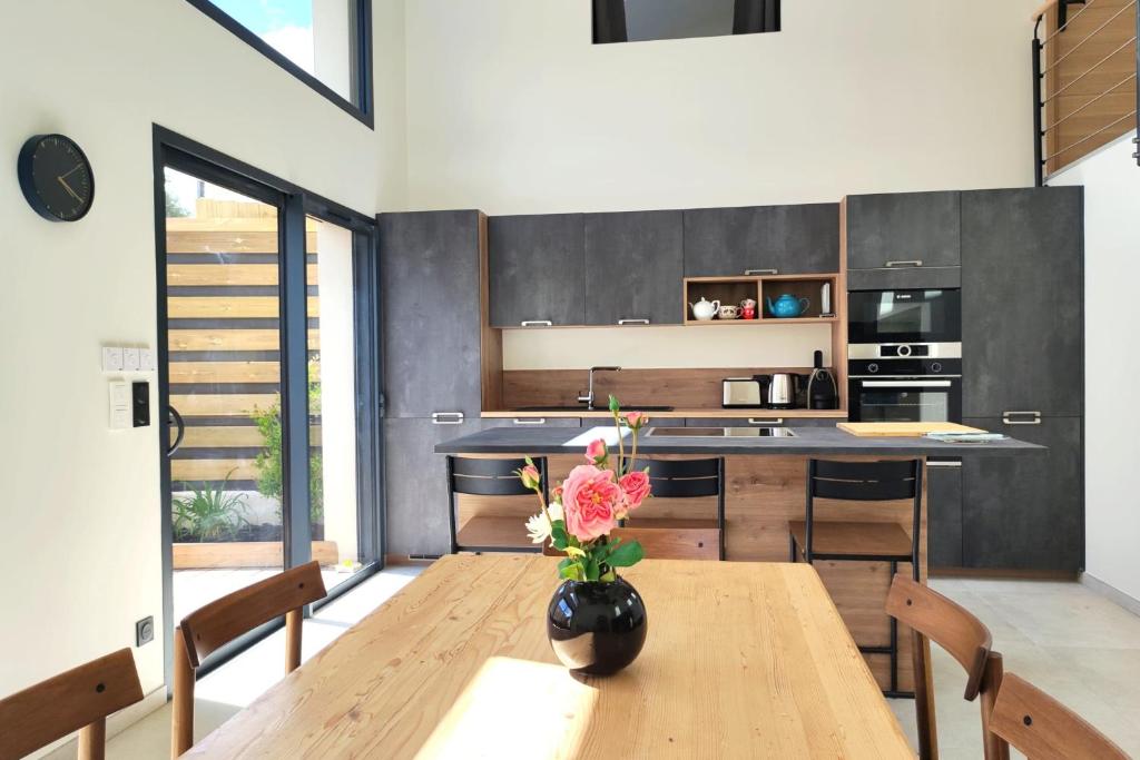 une cuisine avec une table en bois et un vase de fleurs. dans l'établissement Beautiful house near the Parc Bordelais, à Bordeaux