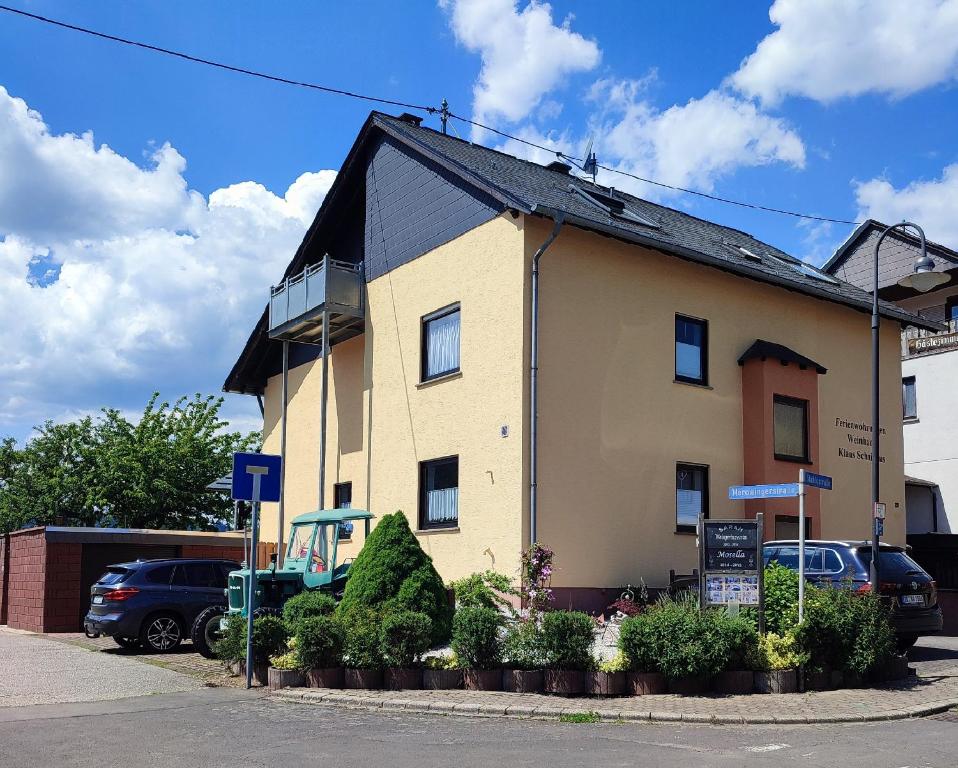 a yellow building with a black roof on a street at Ferienwohnungen Klaus u. Bärbel in Kröv