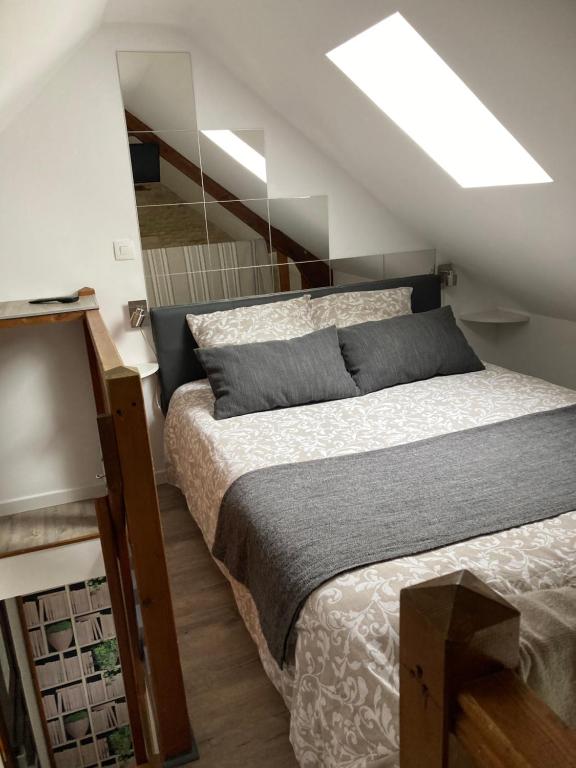 1 dormitorio con 1 cama y tragaluz en JunoGîte - Résidence en Bernières-sur-Mer