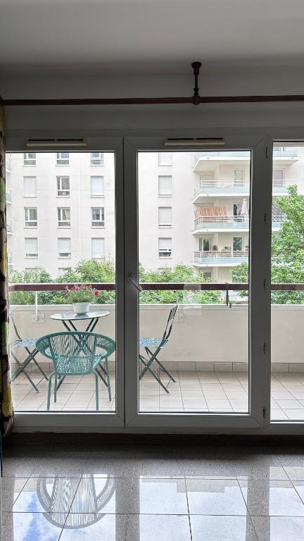 Cette chambre dispose d'une terrasse avec une table et des chaises. dans l'établissement Cozy apartment near La Défense & Paris La Défense Arena, à Courbevoie