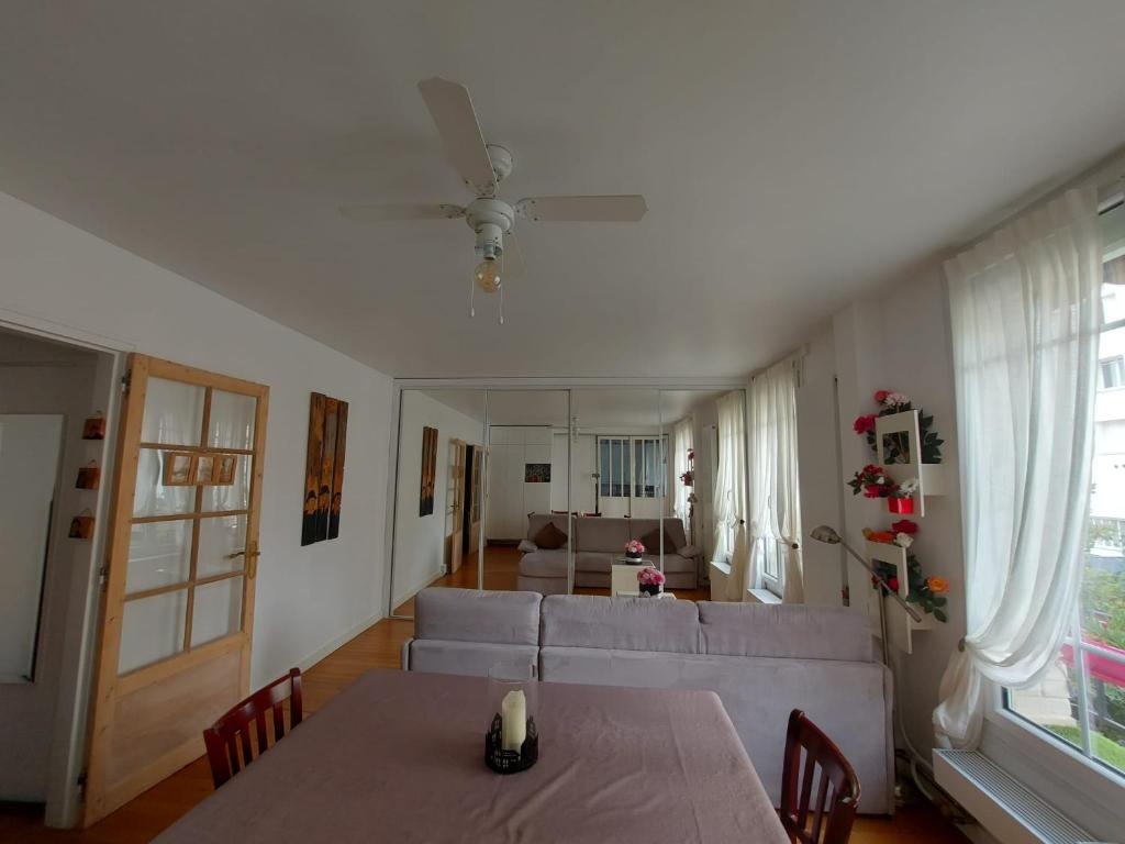 un salon avec une table et un canapé dans l'établissement 4 pièces parking proche paris, à Courbevoie