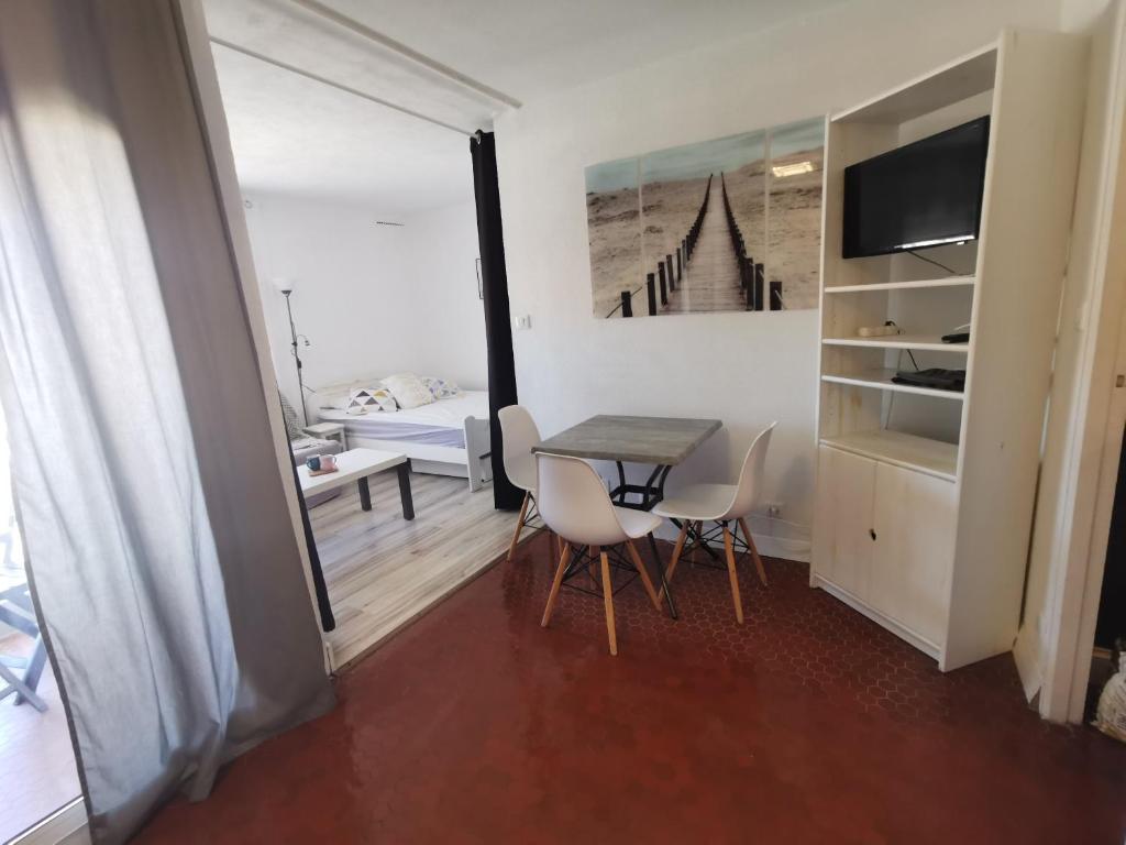 une pièce avec une table et des chaises et une chambre dans l'établissement Soleil Levant 2 - En bord de mer - Superbe Appartement Cosy - Accès direct plage - Proche Commerces et Animations, au Barcarès