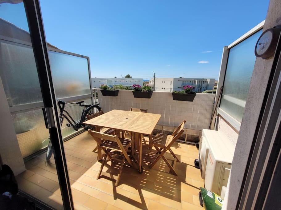 d'un balcon avec une table et des chaises en bois sur le toit. dans l'établissement La Parenthèse Marine, à Bandol