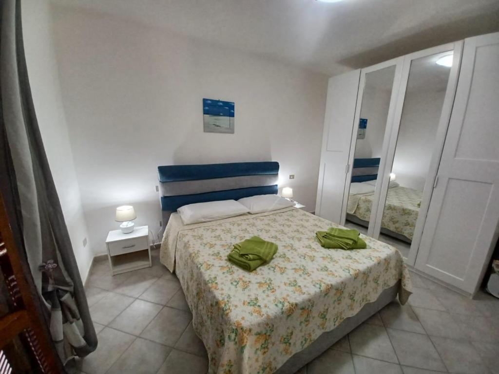 um quarto com uma cama com duas almofadas verdes em CASA SIBILLA bi-locale con terrazza a 60 metri dal mare em Marinella