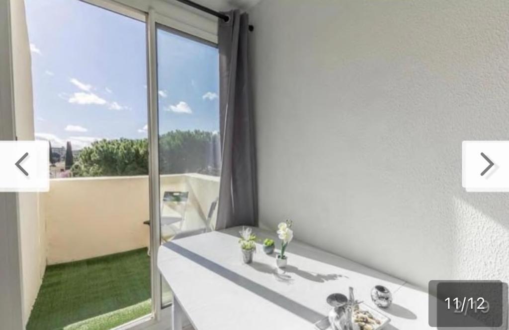 um quarto branco com uma grande janela com vista em Montpellier : Jolie studio très calme em Montpellier