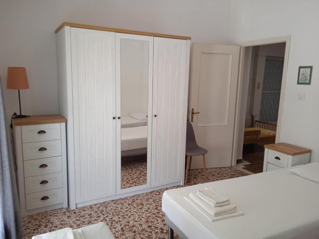a bedroom with a large white cabinet with a mirror at Elinas Room in Poros