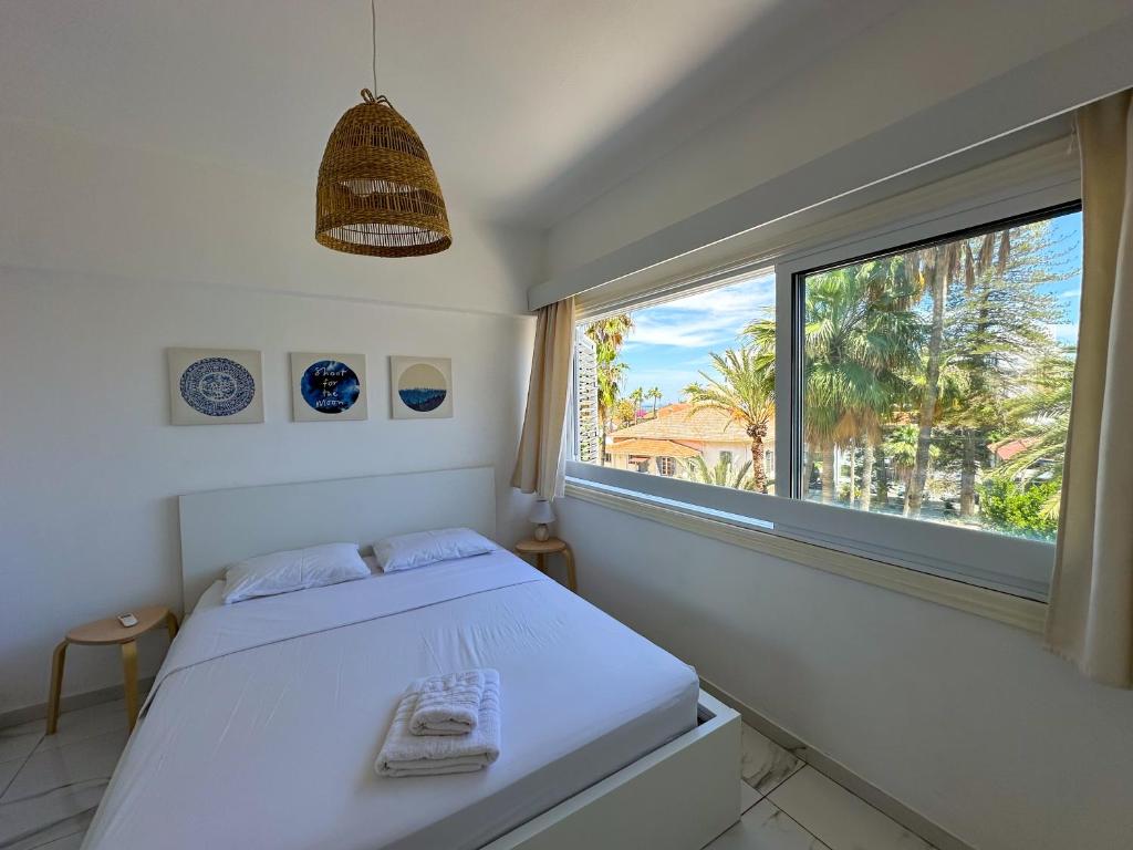 a bedroom with a bed and a large window at Real Center in Larnaka