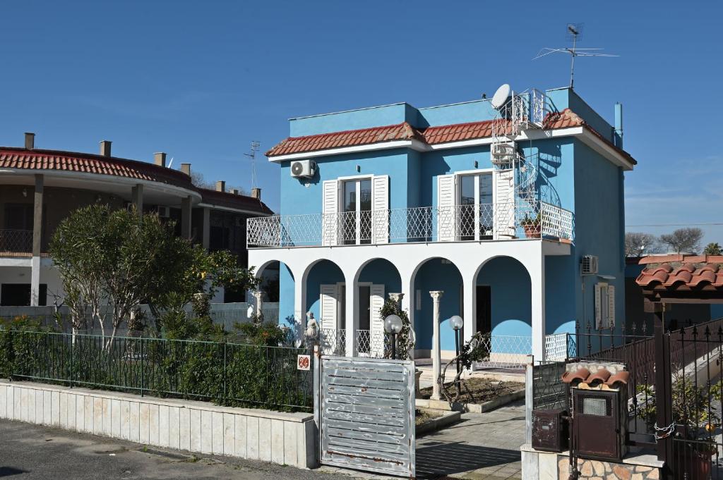a blue and white house with a fence at Casa Benesere Corpo E Mente in Castel Volturno