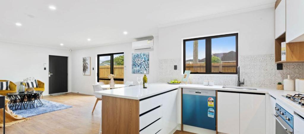 a kitchen with white cabinets and a blue refrigerator at Holiday Home or Short term Rental in Papatoetoe in Auckland