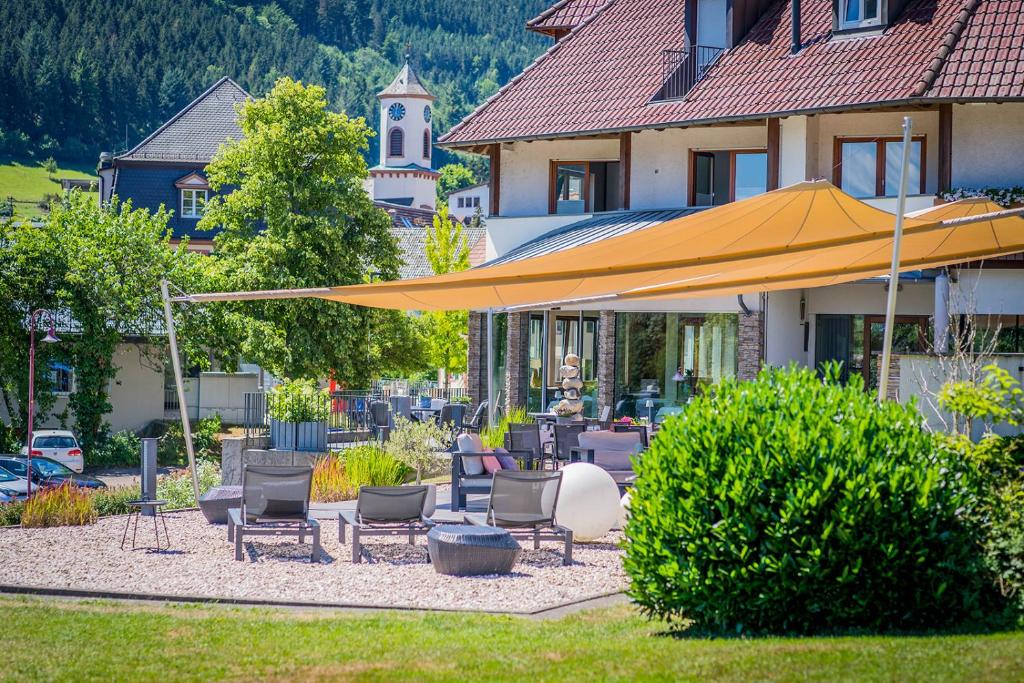 a patio with chairs and an umbrella in front of a house at Gasthaus Linde in Hofstetten