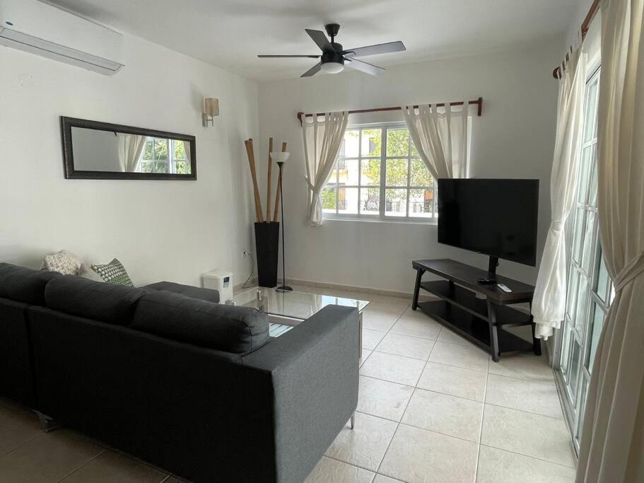 Il comprend un salon doté d'un canapé noir et d'une télévision à écran plat. dans l'établissement Amplio departamento en 5ta av, à Playa del Carmen