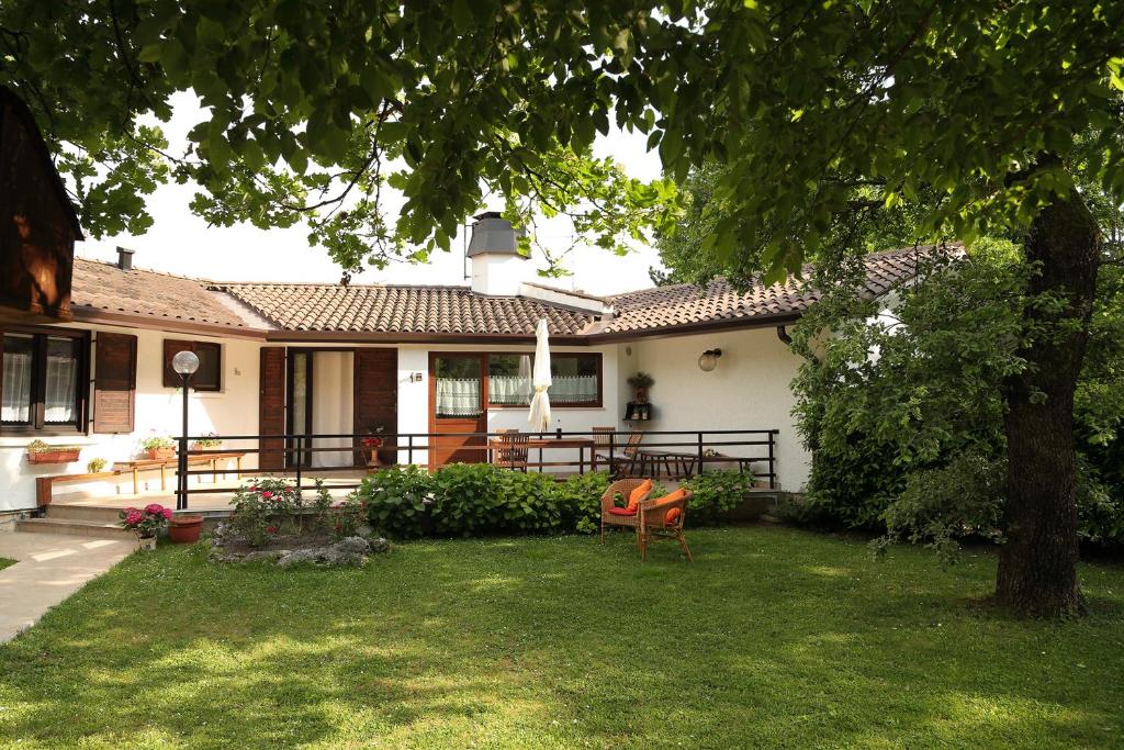 una casa con un árbol y una silla en el patio en villa Marina, en Borgo Grotta Gigante