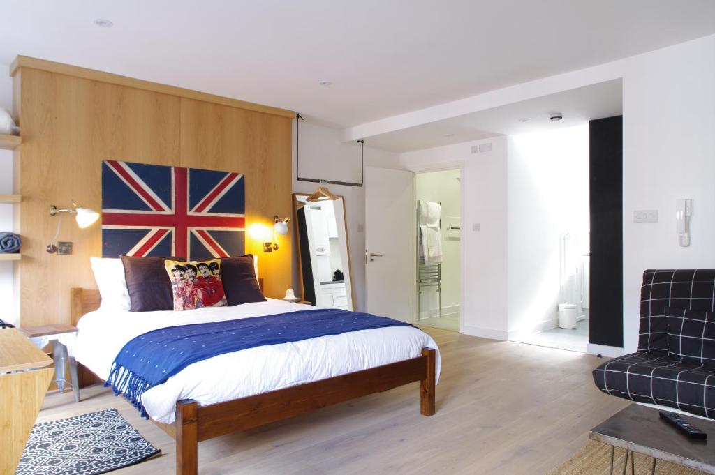 Schlafzimmer mit einem Bett mit einer Flagge am Kopfteil in der Unterkunft Stylish Fitzrovia Studios W1 in London