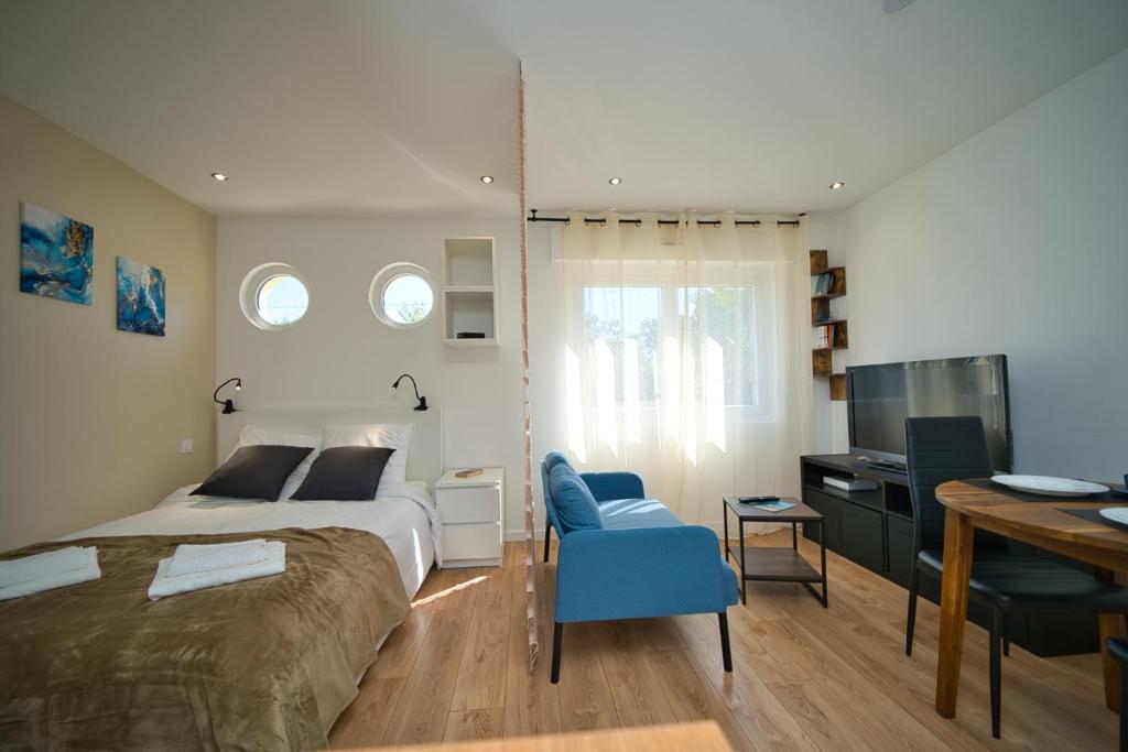 une chambre avec un lit, un bureau et une télévision dans l'établissement Studio climatisé refait à neuf, à Villeneuve-Loubet