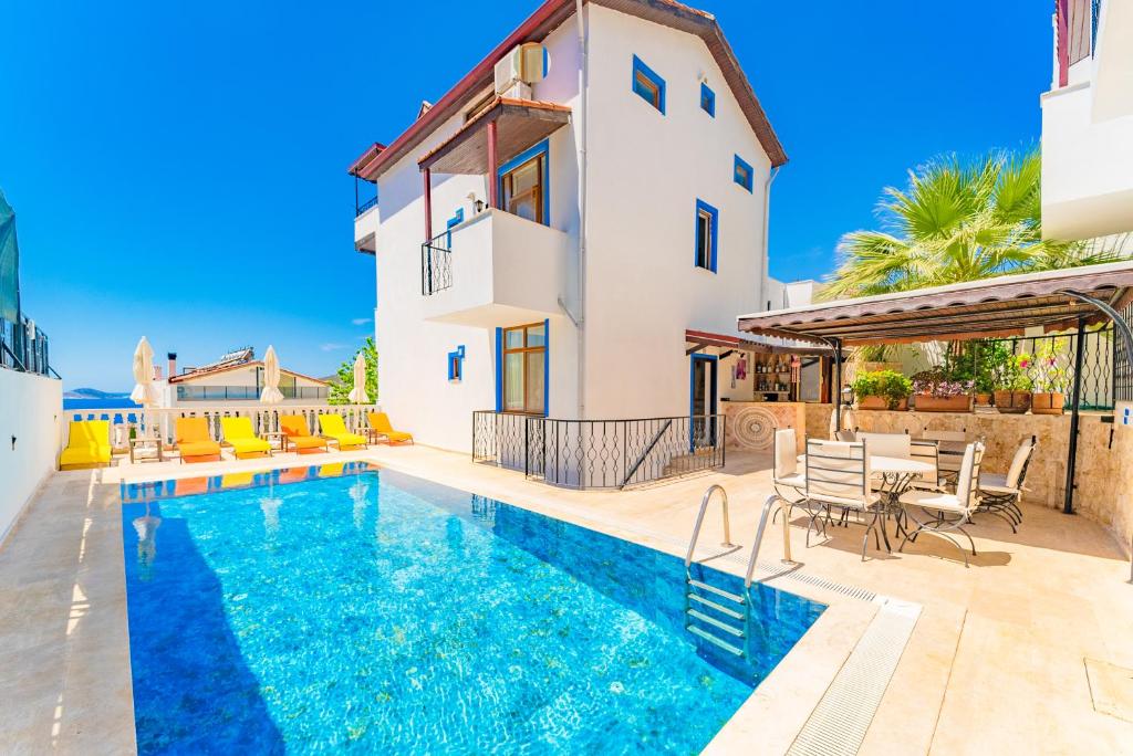 a villa with a swimming pool and a house at Pazar Apartments in Kalkan
