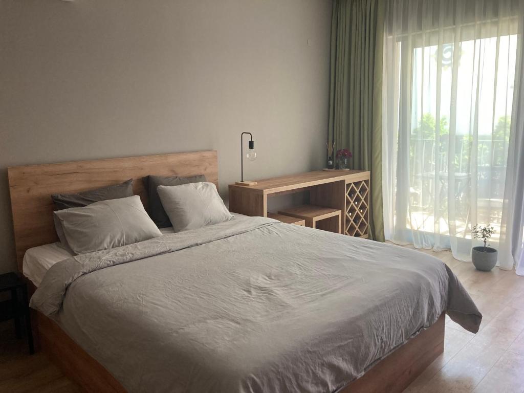 a bedroom with a large bed and a window at Cozy studio by the seaside in Byala