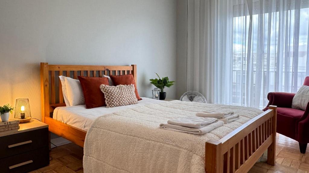 a bedroom with a large bed with towels on it at Sunny 4 Bedroom Apartment - with View in Coimbra