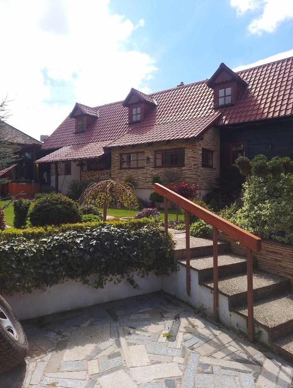 a house with a wooden staircase in front of it at Chalupa u Záhradníkov in Trebostovo