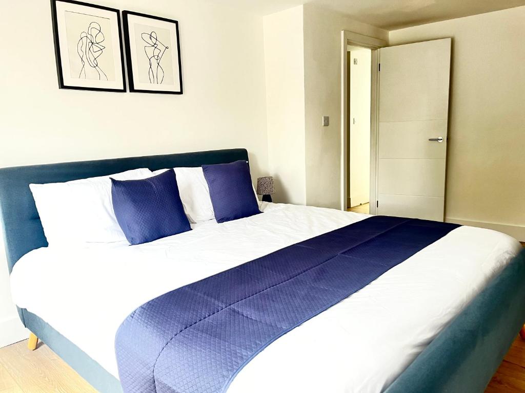 a bedroom with a large blue and white bed at Maidstone City Centre Penthouse Apartment in Kent