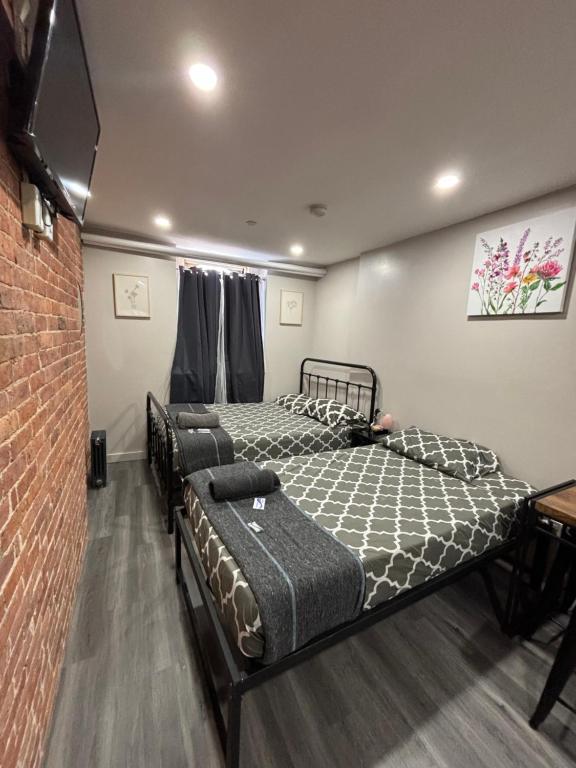 a bedroom with two beds and a brick wall at 31 Street Broadway Hotel in New York