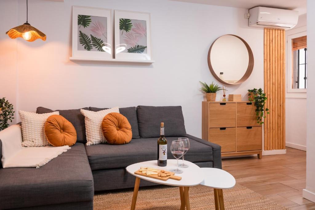a living room with a couch and a table with a bottle of wine at Refugio en Albaicín y parking in Granada
