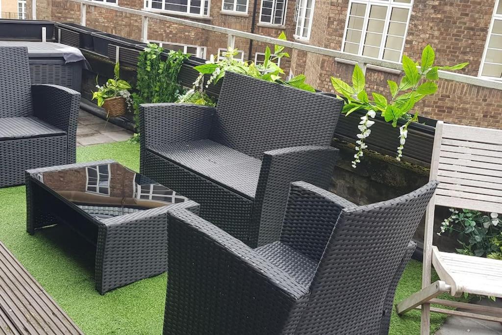 a patio with wicker chairs and a table at Studio apt with HUGE balcony near Oxford st - Marble arch - HydePark in London