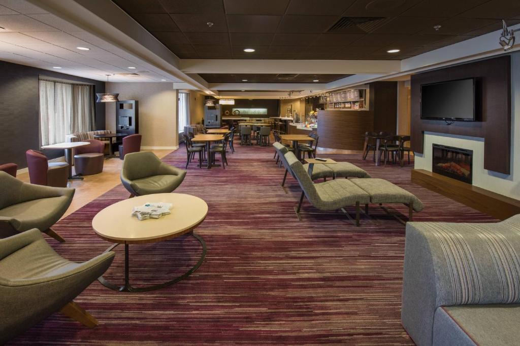 a waiting room with chairs and tables and a fireplace at Courtyard by Marriott Scranton Montage Mountain in Moosic