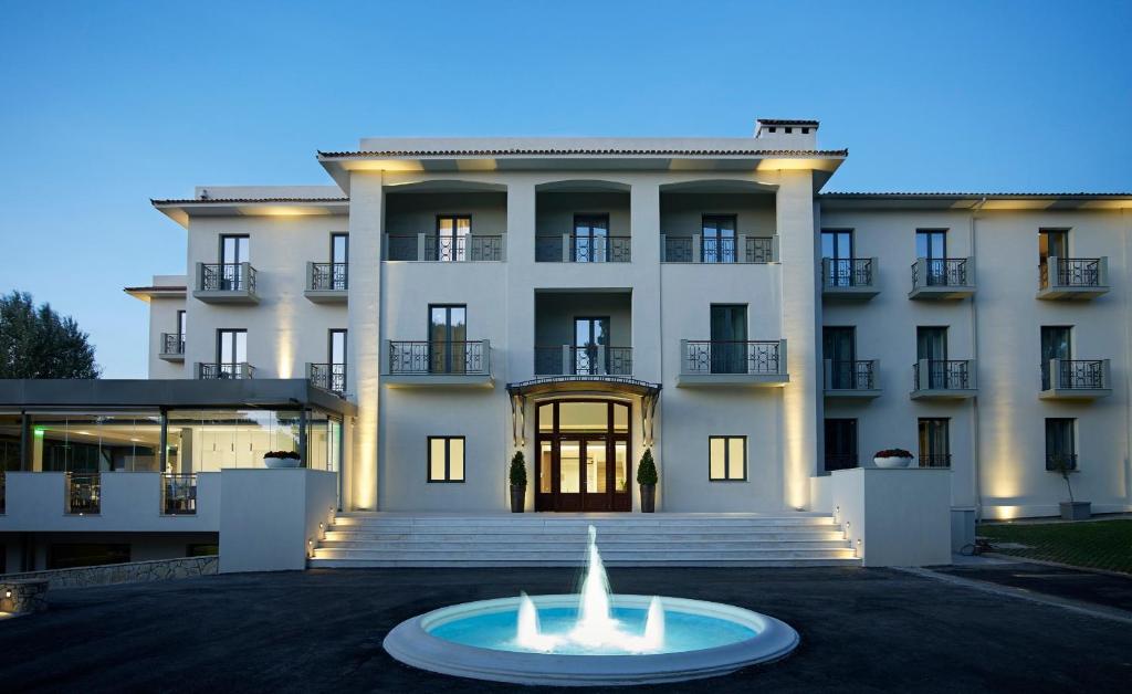 a large white building with a fountain in front of it at Domotel Kastri in Athens