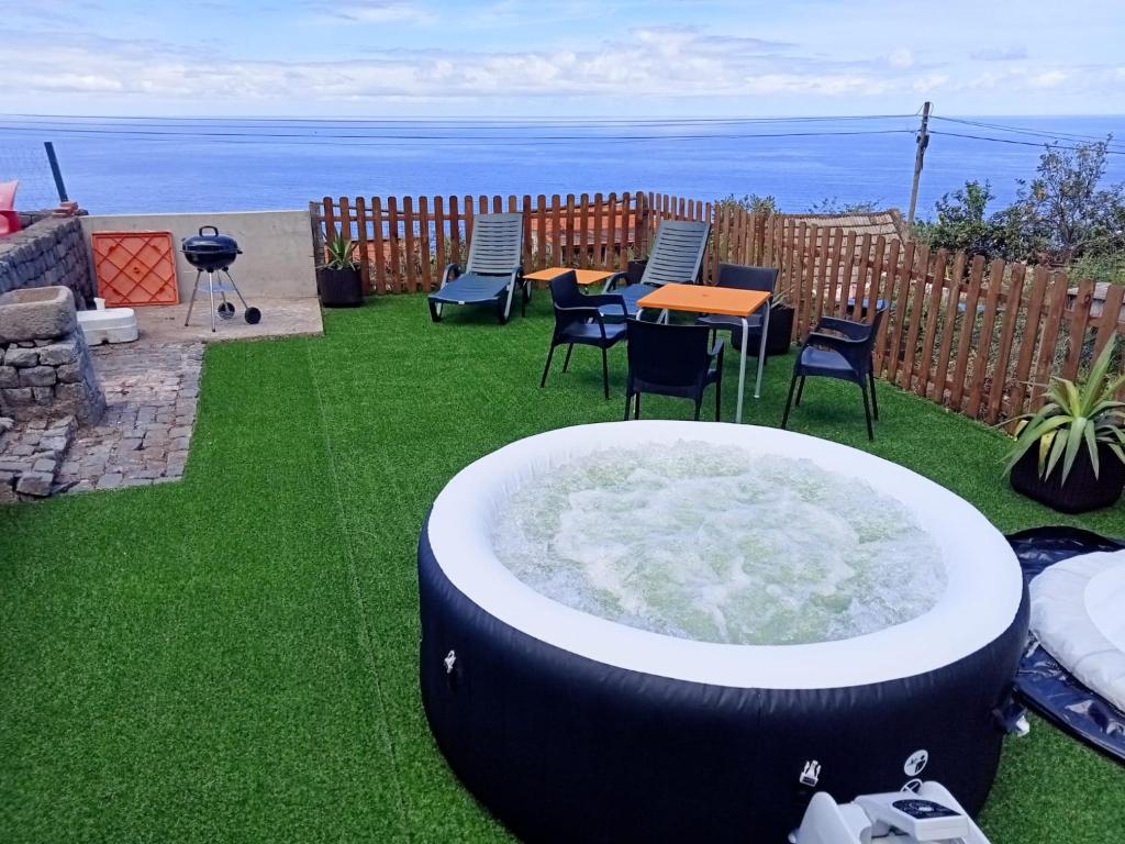 uma banheira de hidromassagem na relva com cadeiras e uma mesa em Lombada Villa Comfort em Ponta Delgada