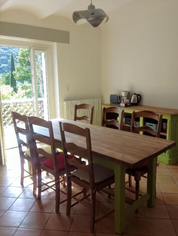 une table et des chaises en bois dans une chambre avec une table dans l'établissement Gite les kiwis, à Bessèges