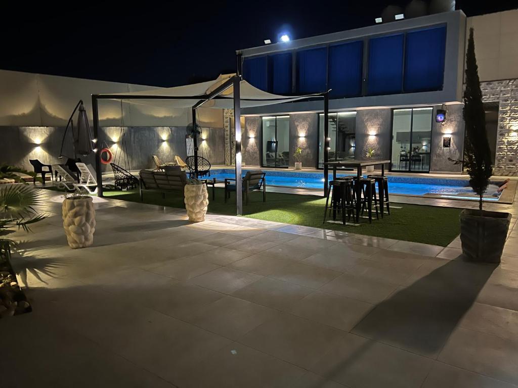 una casa con piscina por la noche en The Sea Villa, en Sowayma