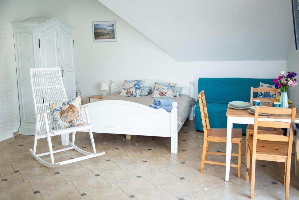 Pokój z łóżkiem, stołem i krzesłami w obiekcie Gwiazda Morska w Karwieńskim Błocie