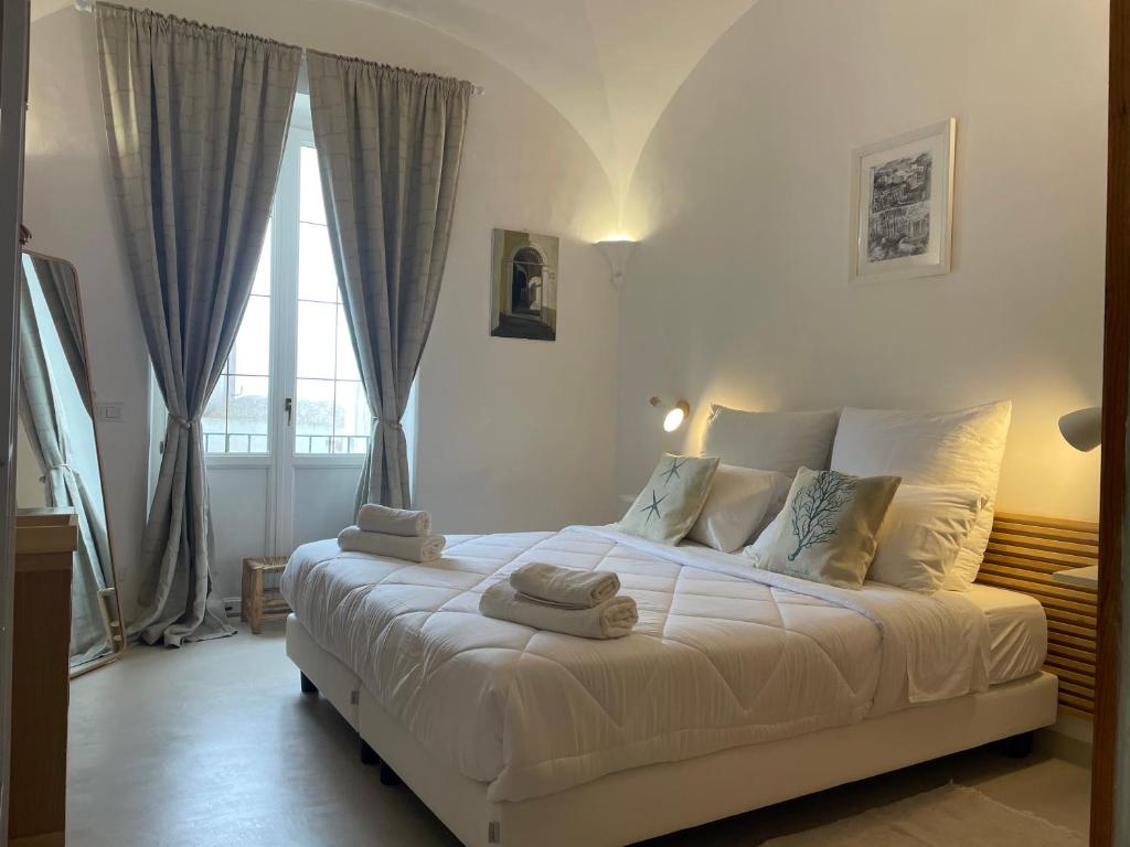 a bedroom with a white bed with towels on it at Casa Amelia in Capri