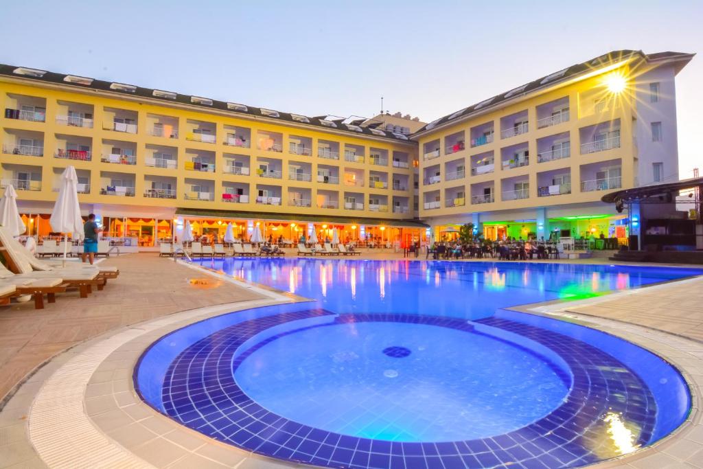 a hotel with a swimming pool in front of a building at Pine House by Werde Hotels in Kemer