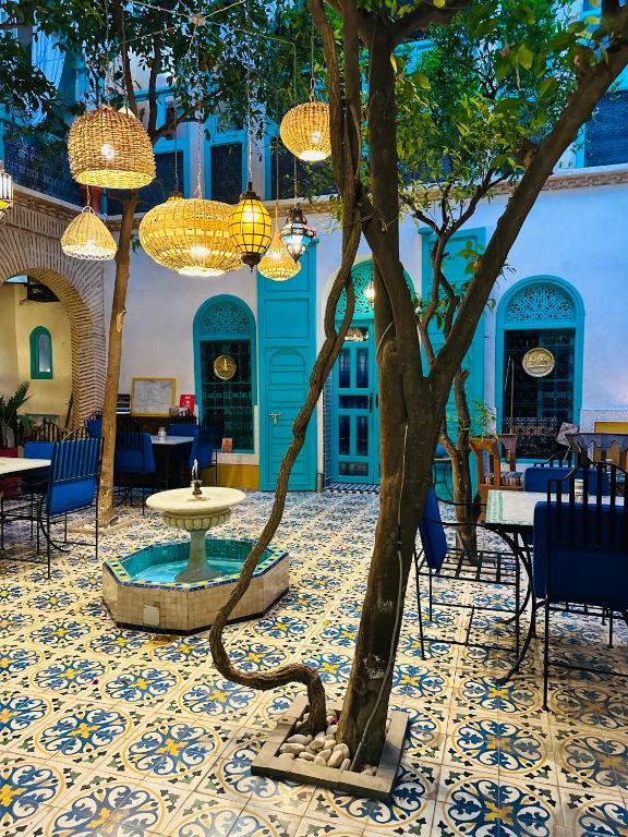 a courtyard with a tree and chandeliers at Riad Al Nour in Marrakech