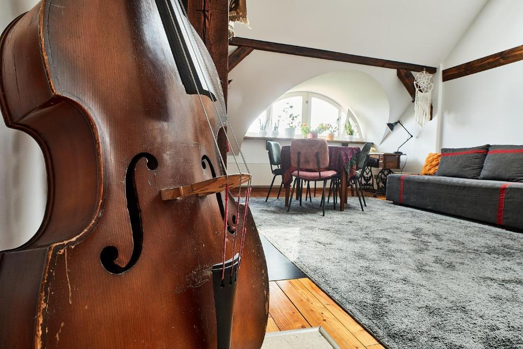 duże drewniane skrzypce siedzące w salonie w obiekcie Cesar Apartment we Wrocławiu