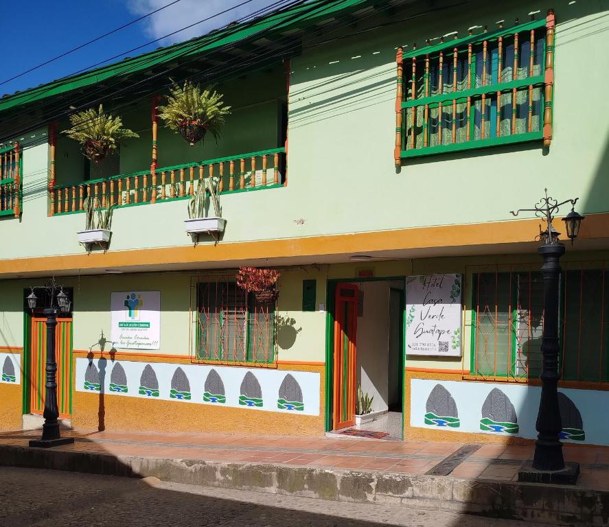 un edificio con puertas y ventanas coloridas y luz de la calle en Hotel Casa Verde Guatapé, en Guatapé
