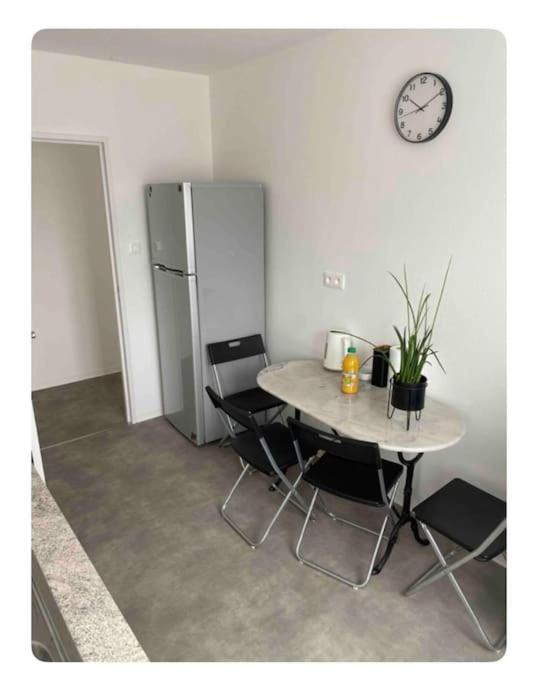 une table et des chaises dans une pièce avec une horloge au mur dans l'établissement Chaleureux et spacieux Cernay80, à Cernay