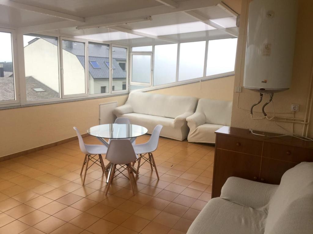 ein Wohnzimmer mit einem Sofa, einem Tisch und Stühlen in der Unterkunft Terraza de las Gaviotas in San Cosme de Barreiros