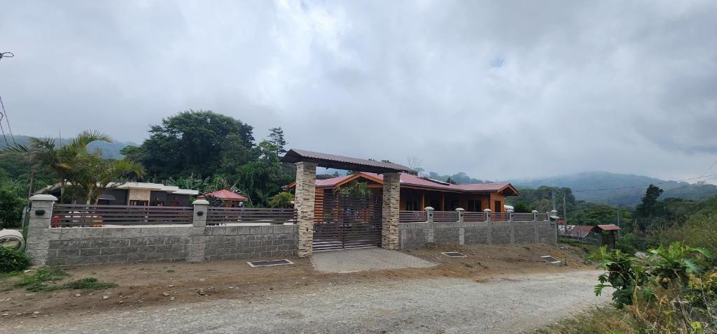 a house with a stone wall and a fence at Cabina monteverde Soan de Montaña in Monteverde Costa Rica