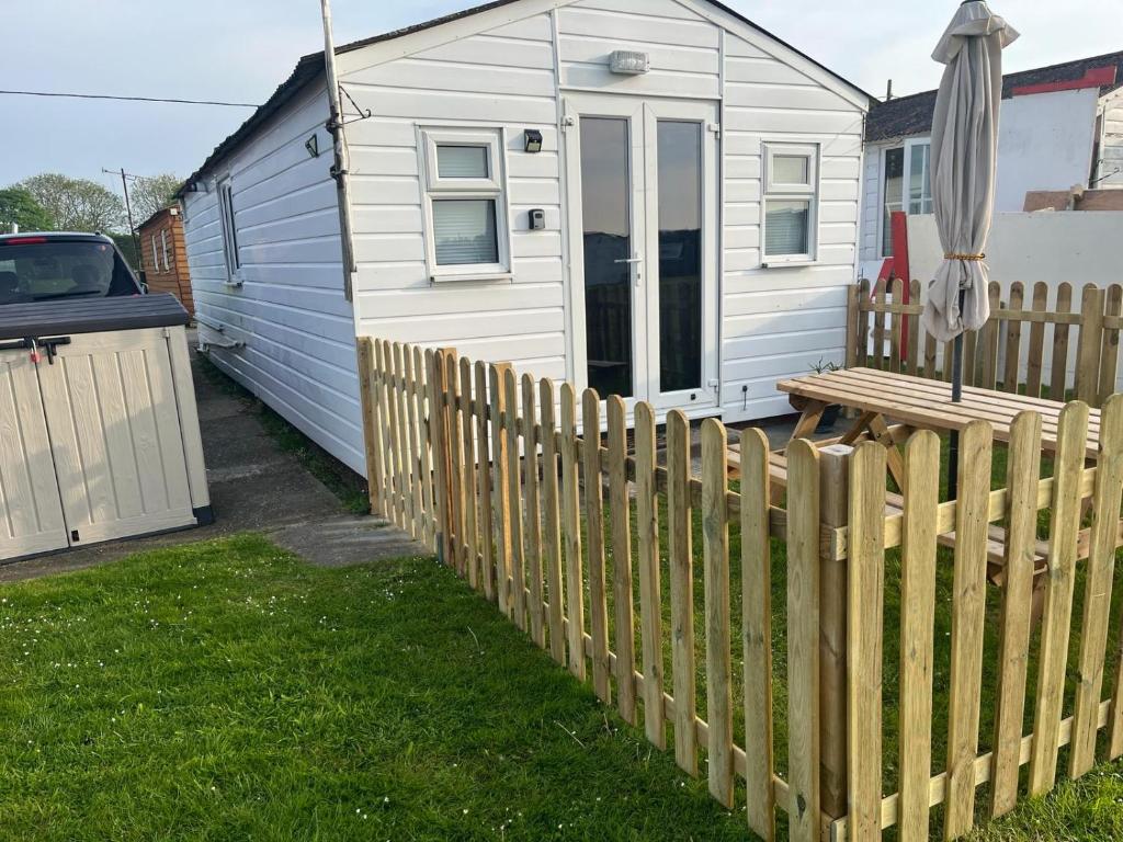 una valla de madera frente a una casa en All Seasons Chalet Breaks en Leysdown-on-Sea