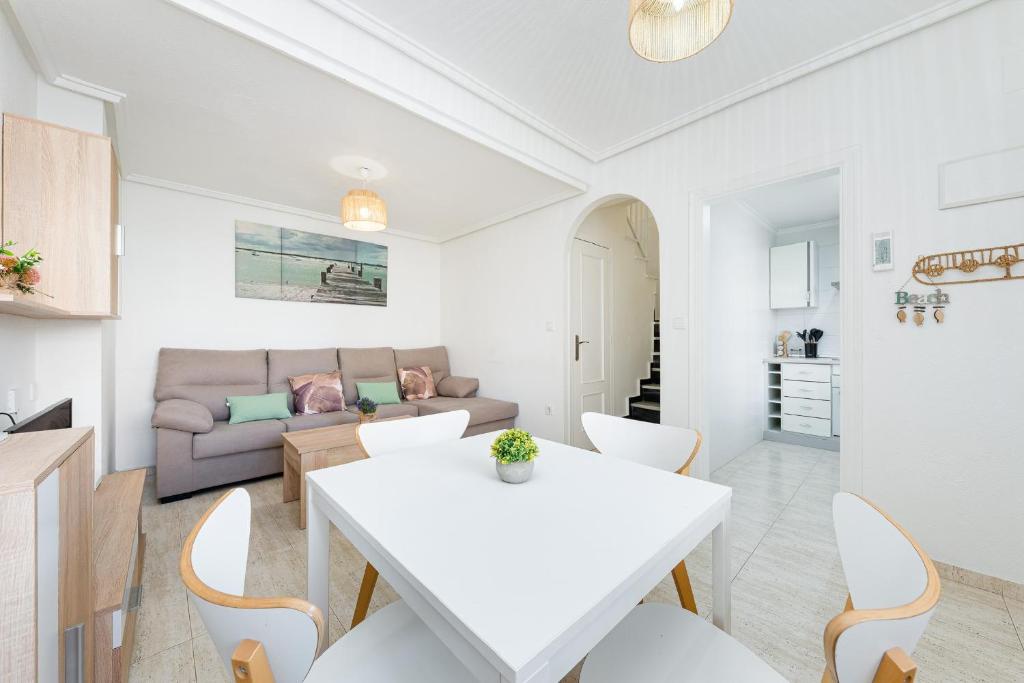 een woonkamer met een witte tafel en een bank bij Bungalow Aguas Nuevas Sunrise in Torrevieja